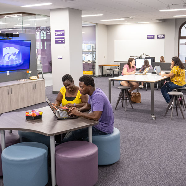 Students working at different tables.