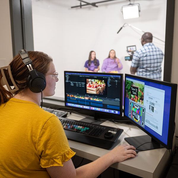 Students film in video production studio.