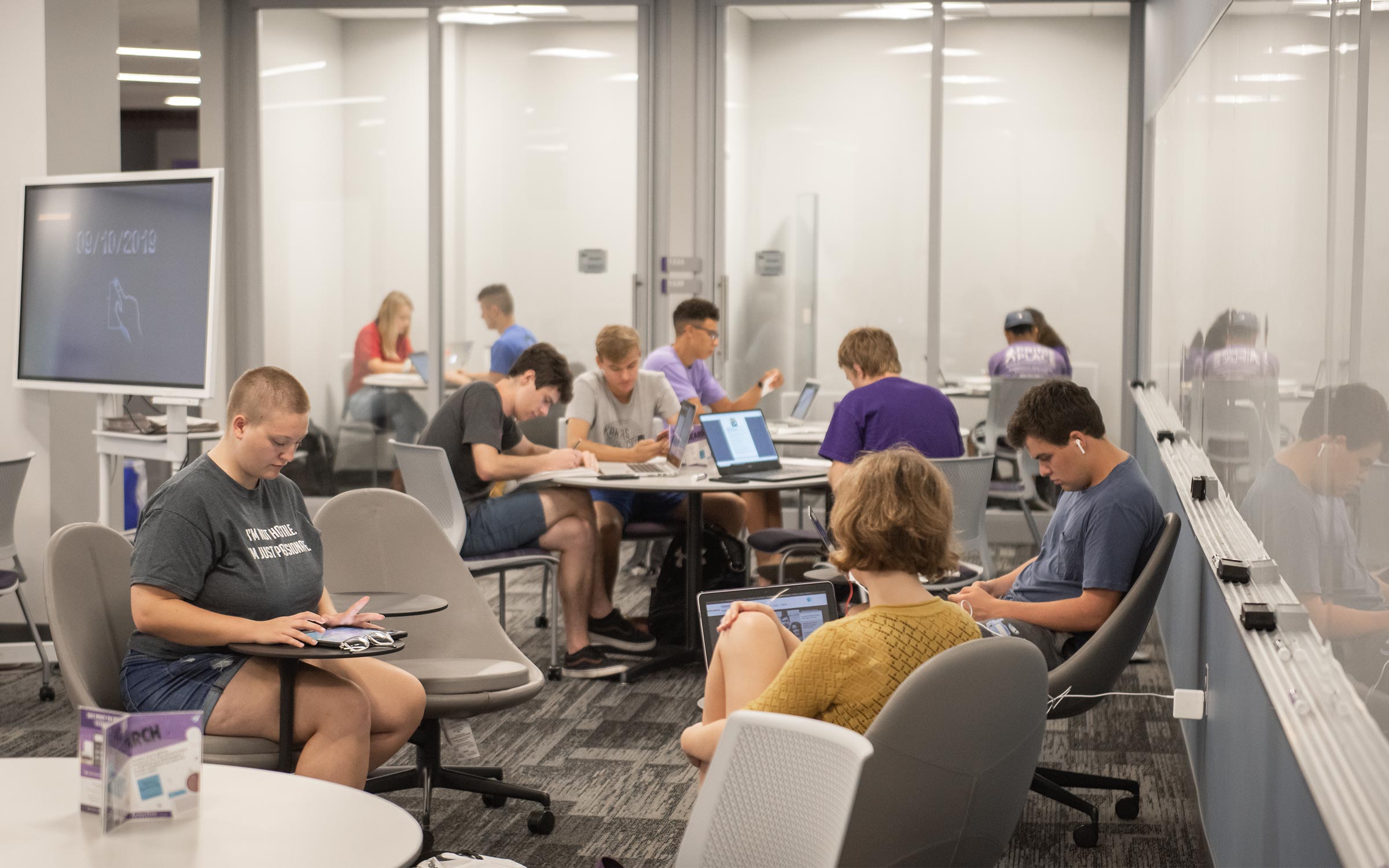 Students sit around tables in the Resource Link.
